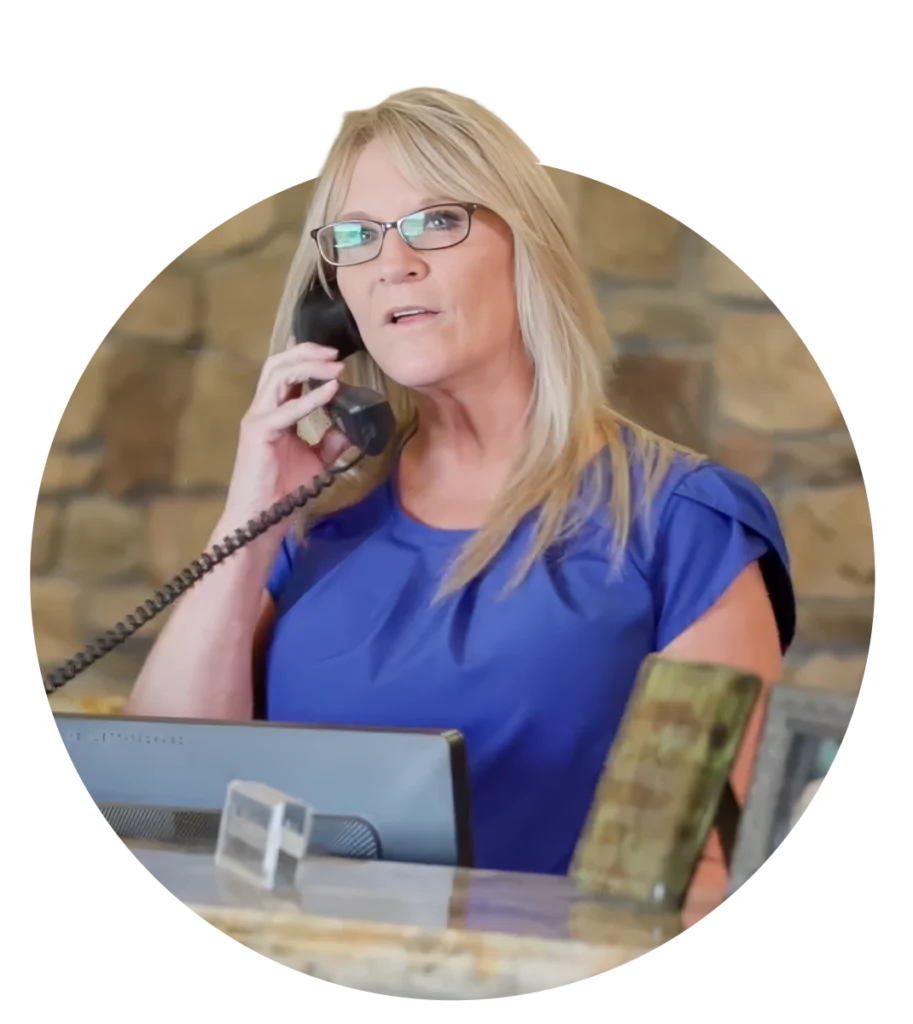 A blonde woman answering the phone at an office